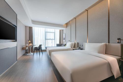 een hotelkamer met 2 bedden en een televisie bij Atour Hotel Xian Economic Development Zone Fengcheng 5th Road in Xi'an