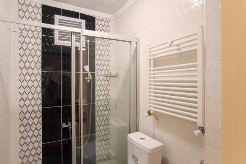 a bathroom with a toilet and a glass shower at Divan Wooden Guesthouse in Istanbul