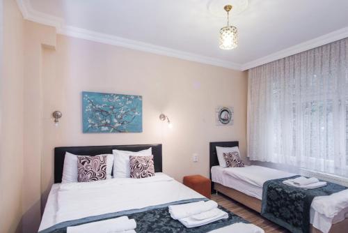 Un dormitorio con dos camas y una ventana. en Divan Wooden Guesthouse, en Estambul