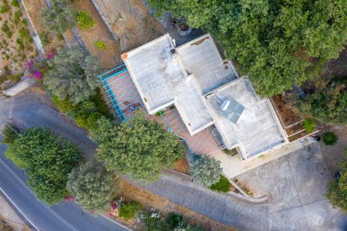 an overhead view of a house with trees and a road at bougainvilla in Fodele