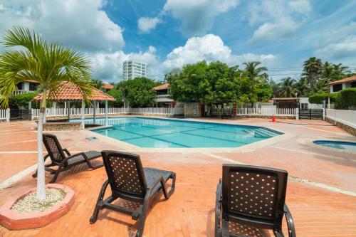 a pool with two chairs and a palm tree at Hermosa Cabana con Piscina 3 Habitaciones MC21 in Coveñitas