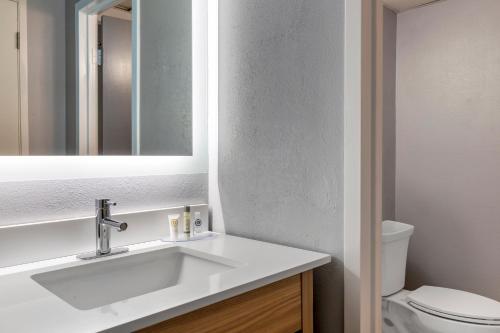 a bathroom with a sink and a toilet and a mirror at Comfort Inn Hyannis - Cape Cod in Hyannis