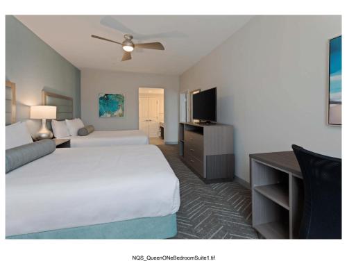 a hotel room with two beds and a flat screen tv at Homewood Suites By Hilton Panama City Beach, Fl in Panama City Beach