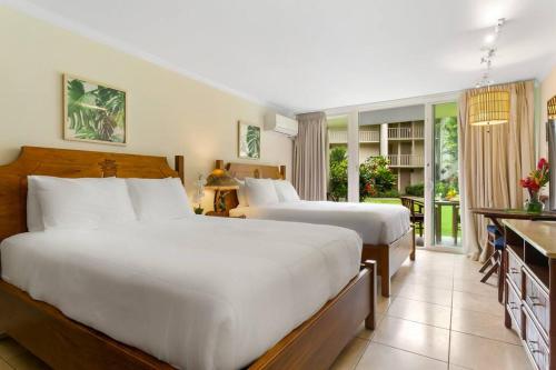 a bedroom with two beds and a balcony at Islander Ocean Resort Condo # 166 in Kapaa