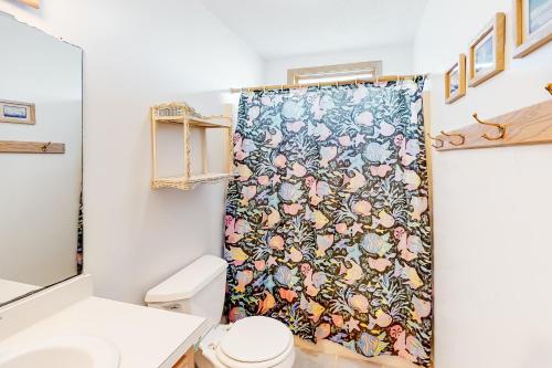 a bathroom with a shower curtain with a toilet at Charmed Life RO22 in Rodanthe