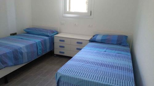 zwei Einzelbetten in einem Zimmer mit Fenster in der Unterkunft Holiday home in Orosei Nuoro Provinz 39543 in Orosei