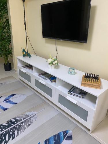a white entertainment center with a flat screen tv on a wall at Casa Apartamento Valentina in Santo Domingo