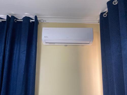 a air conditioner in a room with blue curtains at Casa Apartamento Valentina in Santo Domingo