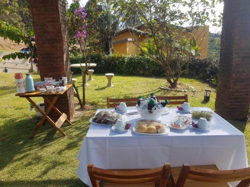 une table blanche avec de la nourriture dans une cour dans l'établissement Molise Hotel Fazenda, à Serra Negra
