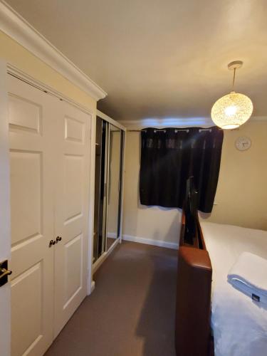 a room with a bed and a window and a door at Lovely 2 Bed Flat/Apt in East London- Nice Estate. in Dagenham