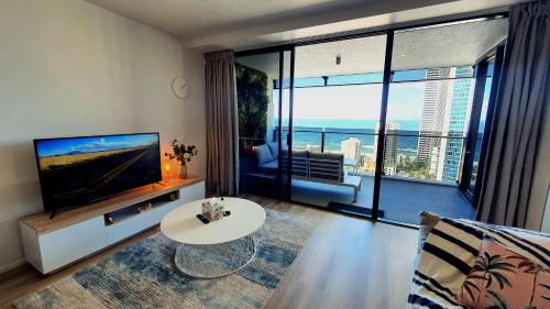 a living room with a television and a large window at OceanView Oasis 2BR Apt - 5Mins to Beach - Family Resort in Gold Coast