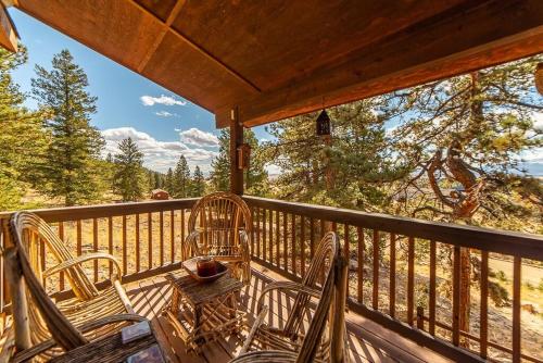 a porch with chairs and a table on a deck at Relax and Unwind with Breathtaking Panoramic Views - Red Hill House in Fairplay