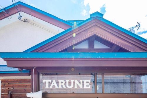 um edifício com um telhado azul com o nome Taminate nele em TARUNE em Otaru