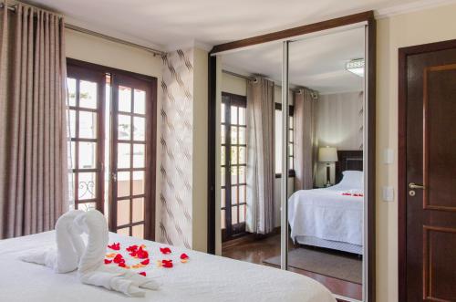 a bedroom with a bed with red roses on it at Pousada da Paz in Curitiba