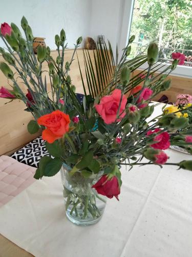 wazon wypełniony kwiatami na stole w obiekcie Zelfies Kunstapartment. w mieście Nonnweiler