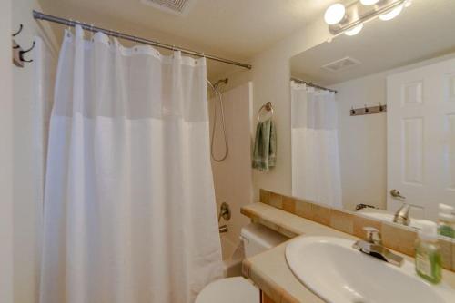 a bathroom with a white shower curtain and a sink at Enjoy the Tiny Home Experience as the Perfect Basecamp to the Rockies! The Northstar Cabin in Fairplay