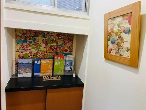 a book shelf with books on it next to a wall at 2025年グッドレビュー賞受賞 広々一軒家 最大9名 空港直通 山手線すぐ80m2庭付き大福ハウス in Tokyo