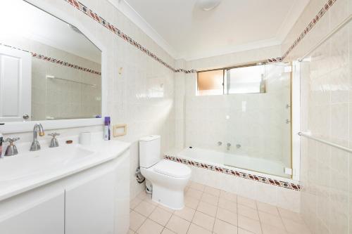 een badkamer met toilet, bad en wastafel bij Oceancrest 15 in Forster