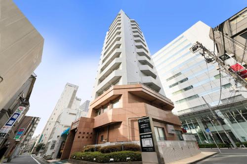 Un palazzo alto nel centro di una città di Hotel Famy Inn Kinshicho a Tokyo