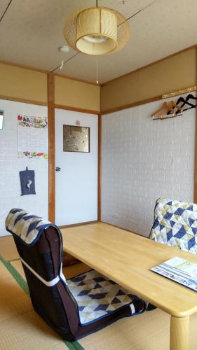 a table and a chair in a room at Guest House Yamada in Date