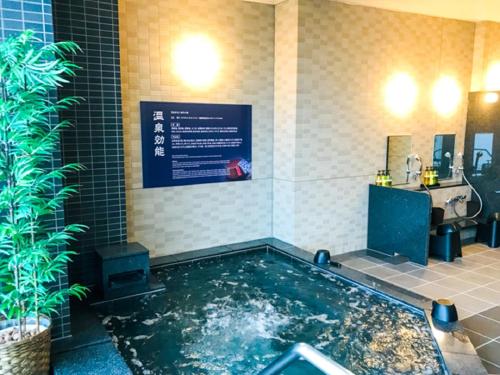 広島市にある天然温泉ホテルリブマックスPREMIUM広島のバスルーム(大きな水プール、シンク付)