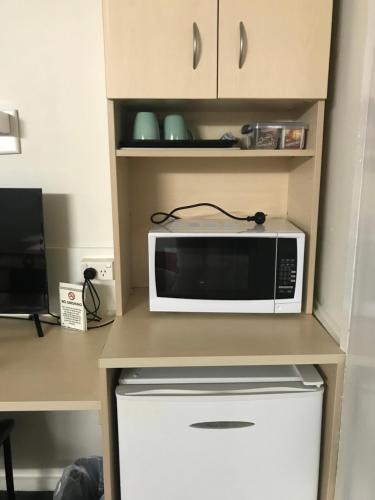 a microwave sitting on top of a kitchen counter at Kaputar Motel in Narrabri