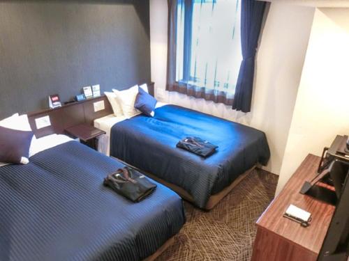 Tempat tidur dalam kamar di Natural Hot Spring Hotel Livemax Premium Hiroshima