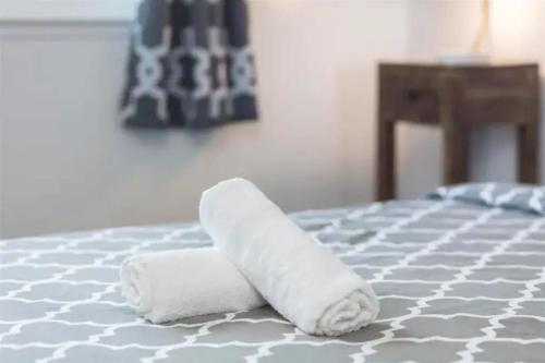 two rolls of toilet paper sitting on top of a bed at Vista Apartment Near Bart and Palaza in Daly City