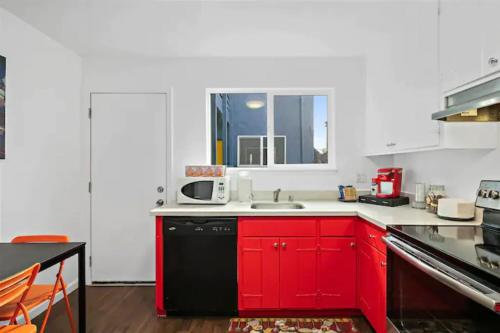 eine Küche mit roten Schränken und einem schwarzen Geschirrspüler in der Unterkunft Vista Apartment Near Bart and Palaza in Daly City