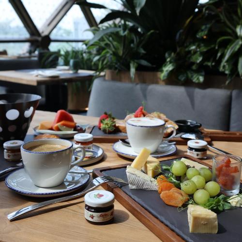 a table with two cups of coffee and plates of food at Dusit Thani Laguna Singapore in Singapore