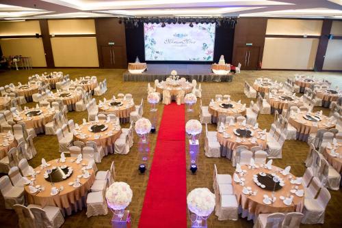 a banquet hall filled with tables and chairs with a red carpet at Ixora Hotel Penang in Perai