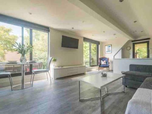 a living room with a couch and a table at Stunning home with hot tub in picturesque village in Haddenham