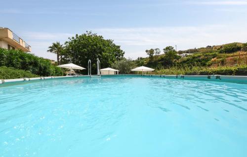 バレストラーテにあるLaila Casa Vacanzaの青い水とパラソル付きの大型スイミングプール