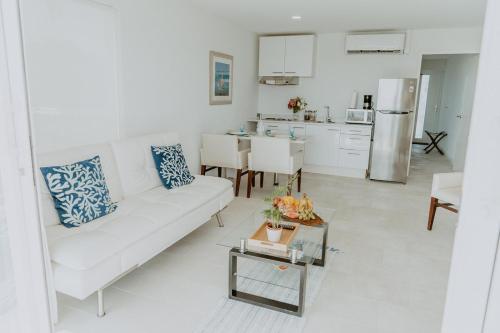 a living room with a white couch and a kitchen at Beachfront Bella Horizonte 4 in Savaneta