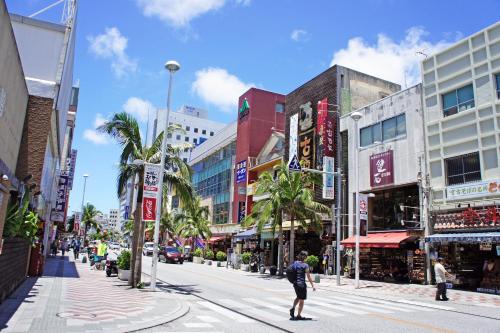 a person crossing a street in a city at Hotel Royal Orion in Naha