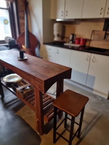 a wooden table and a stool in a kitchen at Odessa at leavers Hotel in Creswick