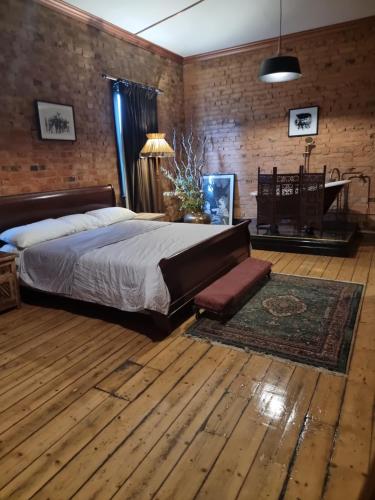 a bedroom with a large bed and a piano at Odessa at leavers Hotel in Creswick