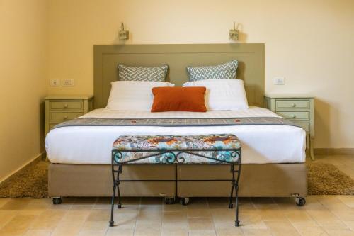 a bedroom with a large bed with two pillows at Yehelim Boutique Hotel in Arad