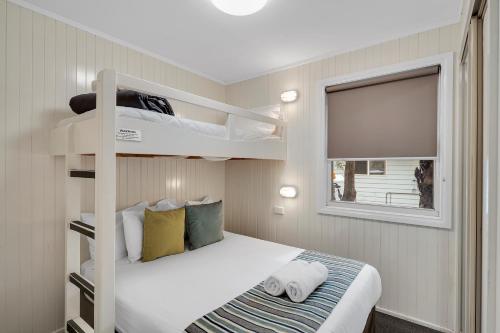 a bedroom with two bunk beds and a window at Ingenia Holidays One Mile Beach in One Mile
