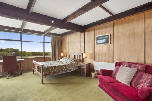 een slaapkamer met een bed en een bank in een kamer bij Aqua Blue in Apollo Bay