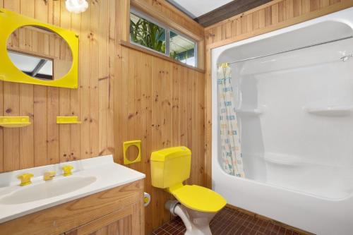 a bathroom with a yellow toilet and a sink at Aqua Blue in Apollo Bay