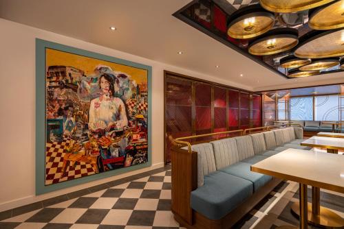 a restaurant with a large painting on the wall at Fusion Original Saigon Centre in Ho Chi Minh City