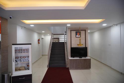a hallway with a staircase with a tv and a television at Chandra Inn in Kollam