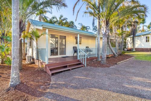 a house with a porch with palm trees at Ingenia Holidays One Mile Beach in One Mile