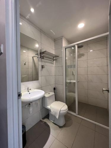 a bathroom with a toilet and a sink and a shower at ZONE Hotels, Telok Panglima Garang in Teluk Panglima Garang