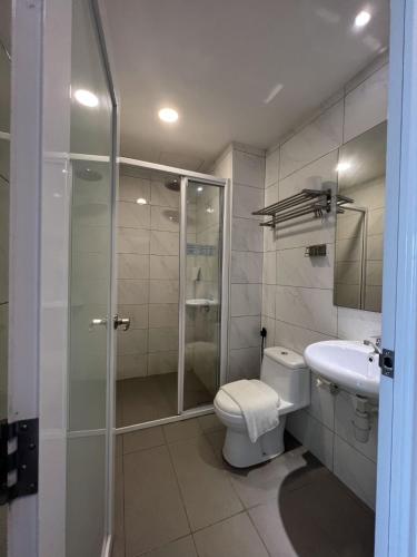 a bathroom with a shower and a toilet and a sink at ZONE Hotels, Telok Panglima Garang in Teluk Panglima Garang