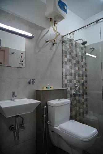 a bathroom with a toilet and a sink at Chandra Inn in Kollam