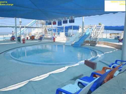 a pool on a cruise ship with chairs and a slide at מגדל אלמוג חיפה - דירות "בלו ביץ'" על הים in Haifa