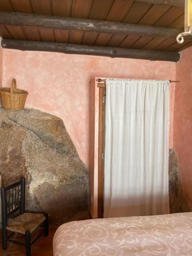 a bedroom with a bed and a window and a chair at Casa Rural El Fontano CR-CC-182 in Montánchez