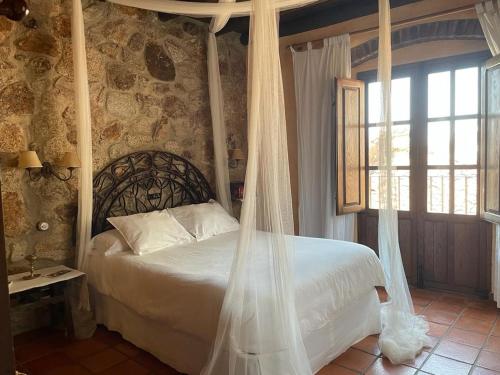 a bedroom with a bed with a mosquito net at Casa Rural El Fontano in Montánchez